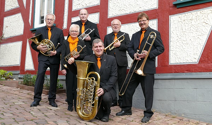 Die Musikgruppe Fulda-Brass mit ihren Blasinstrumenten vor einem Fachwerkhaus