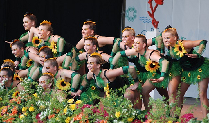 Tanzgruppe in grünem Kostüm mit Sonnenblumen