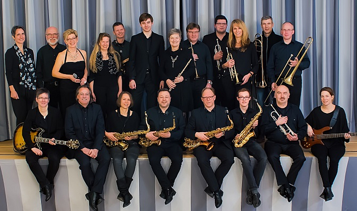 Gruppenfoto der Hartmanns Harmonists mit Instrumenten an der Bühnenkante