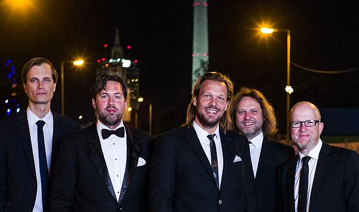 Die fünf Mitglieder der Fuldaer Band Mambo KingX bei Nacht in schwarzem Anzug und Krawatte.