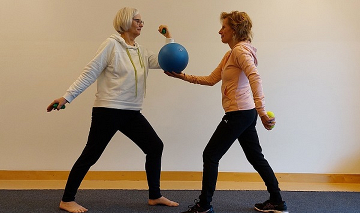 zwei ältere Damen bei einer Gymnastikübung mit Ball