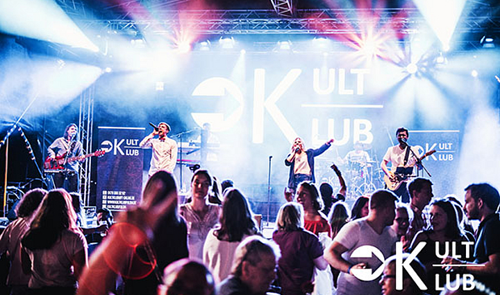 Die Band KultKlub bei einem Showact im Rampenlicht vor jubelnder Menge