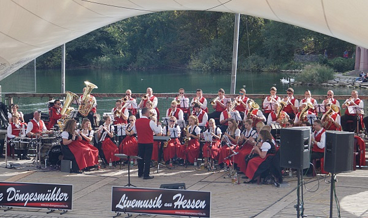 Mitglieder des Musikvereins Döngesmühle in Tracht beim Konzert vor einem See