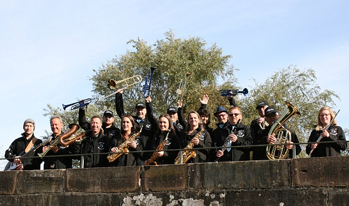 Die Blasmusik Gruppe Lyra in Äktschen mit ihren Instrumenten auf einer Brücke