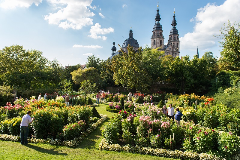 Blick aus dem üppig blühenden Dahliengarten auf den Dom in Fulda